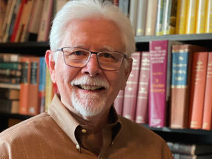Mike Chastain in front of books holding book