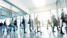Blurred image of business professionals walking through an office, symbolising rushing into AI decisions.