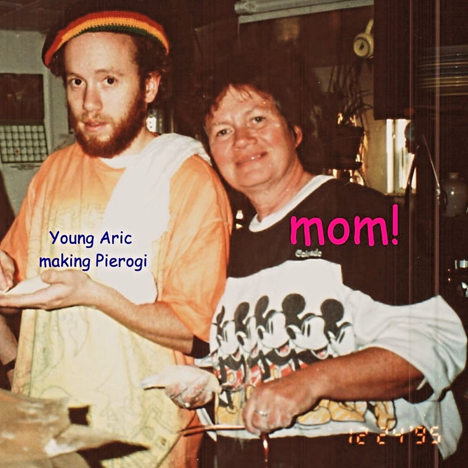 Eric and his mom standing next to each other. Mom is wearing a Micky mouse shirt and Eric in a tie dye orange and white shirt, both smiling. Personal chef on mother's day.
