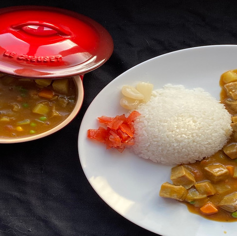 Japanese Beef Curry in a red le creuset disk next to a white plate with rice and curry