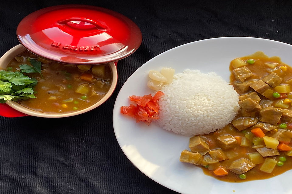Japanese Beef Curry in a red le creuset disk next to a white plate with rice and curry