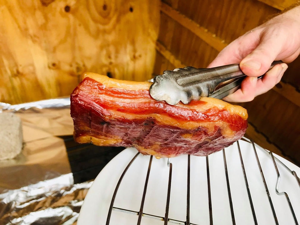 cured meat being help with tongs