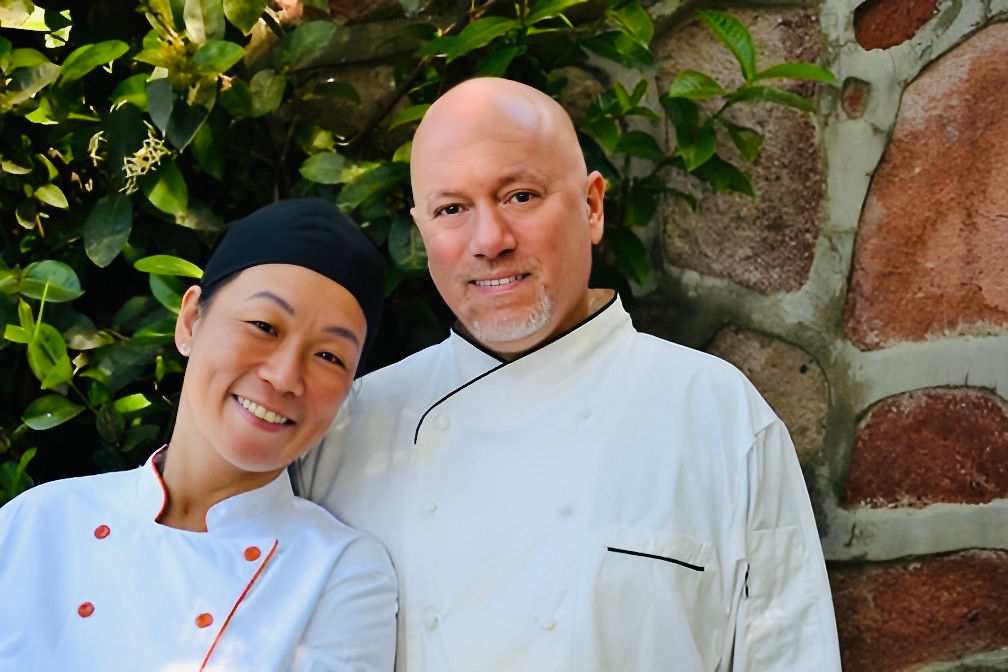Head shot of a couple, Chef Aric and Yukari, white chef coats