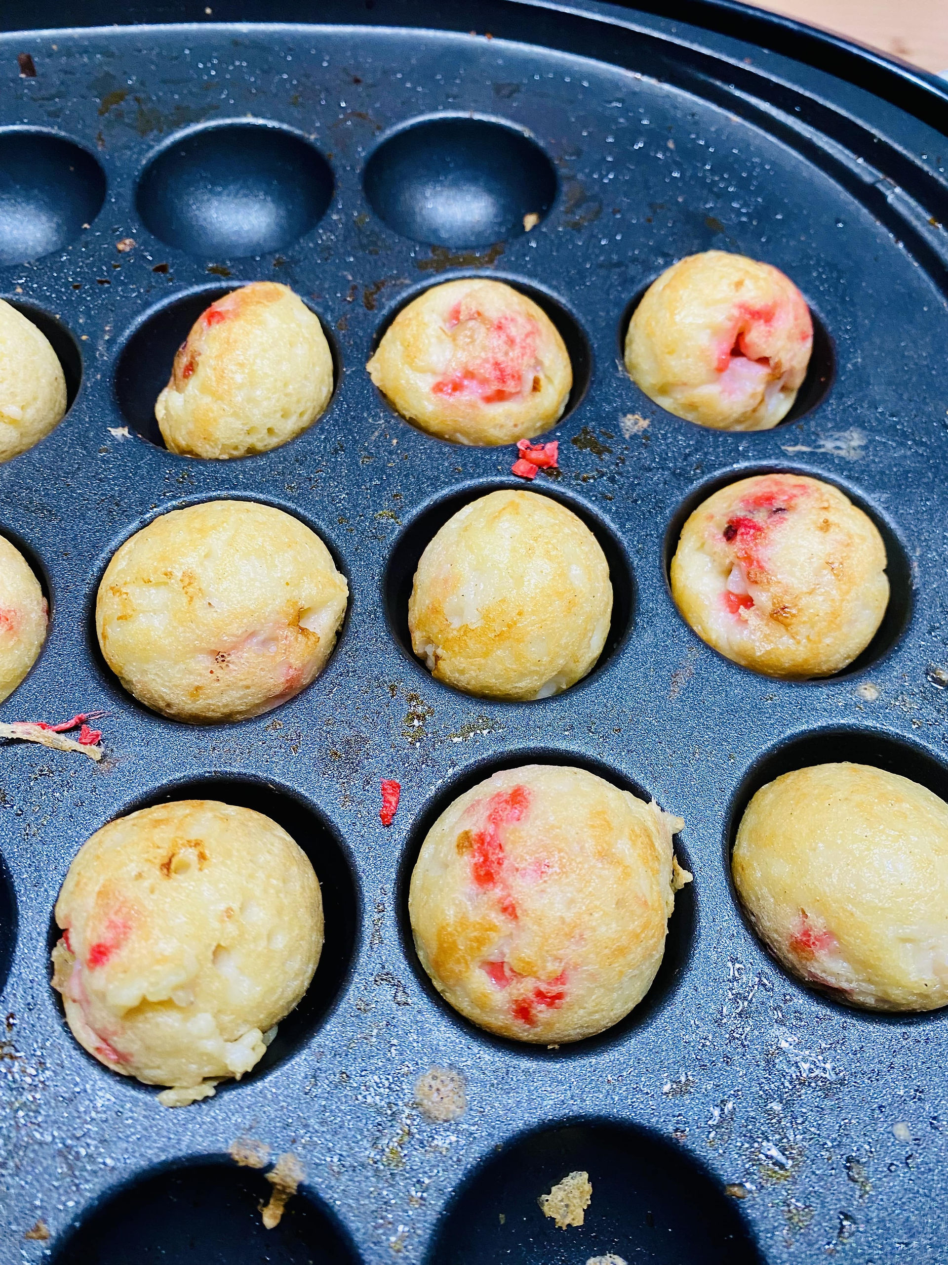 Japanese street food, Tako Yaki (Takoyaki is a ball-shaped Japanese snack made of a wheat flour-based batter filled diced octopus and red ginger in a round shaped molds in a cast iron)  
