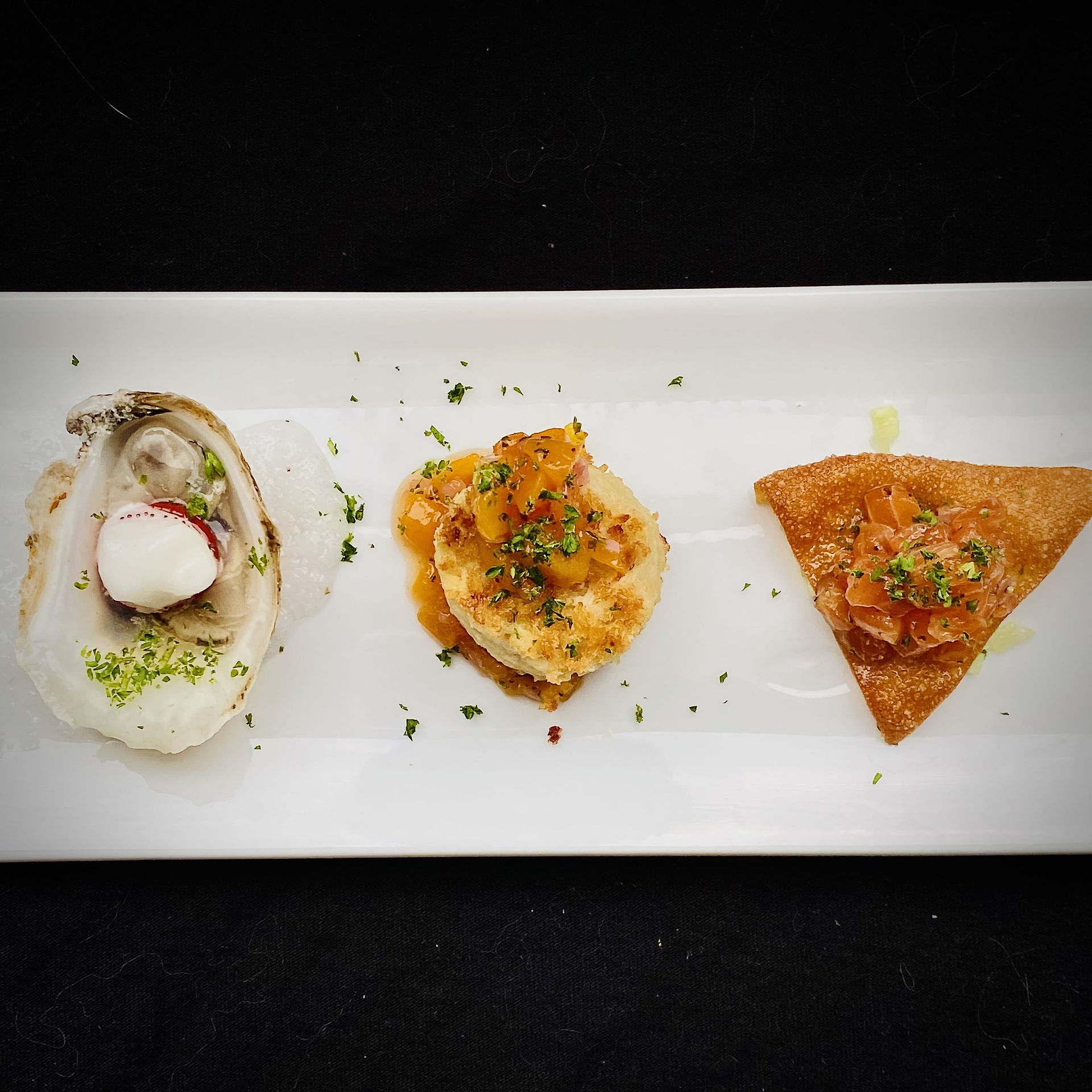 Seafood Appetizer 3 ways: from the left, a Oyster with Fresno Pepper and Sorbet, a Shrimp cake with Spicy Orange Butter Sauce, and a Salmon Tartare with a Crispy Tortilla Chip