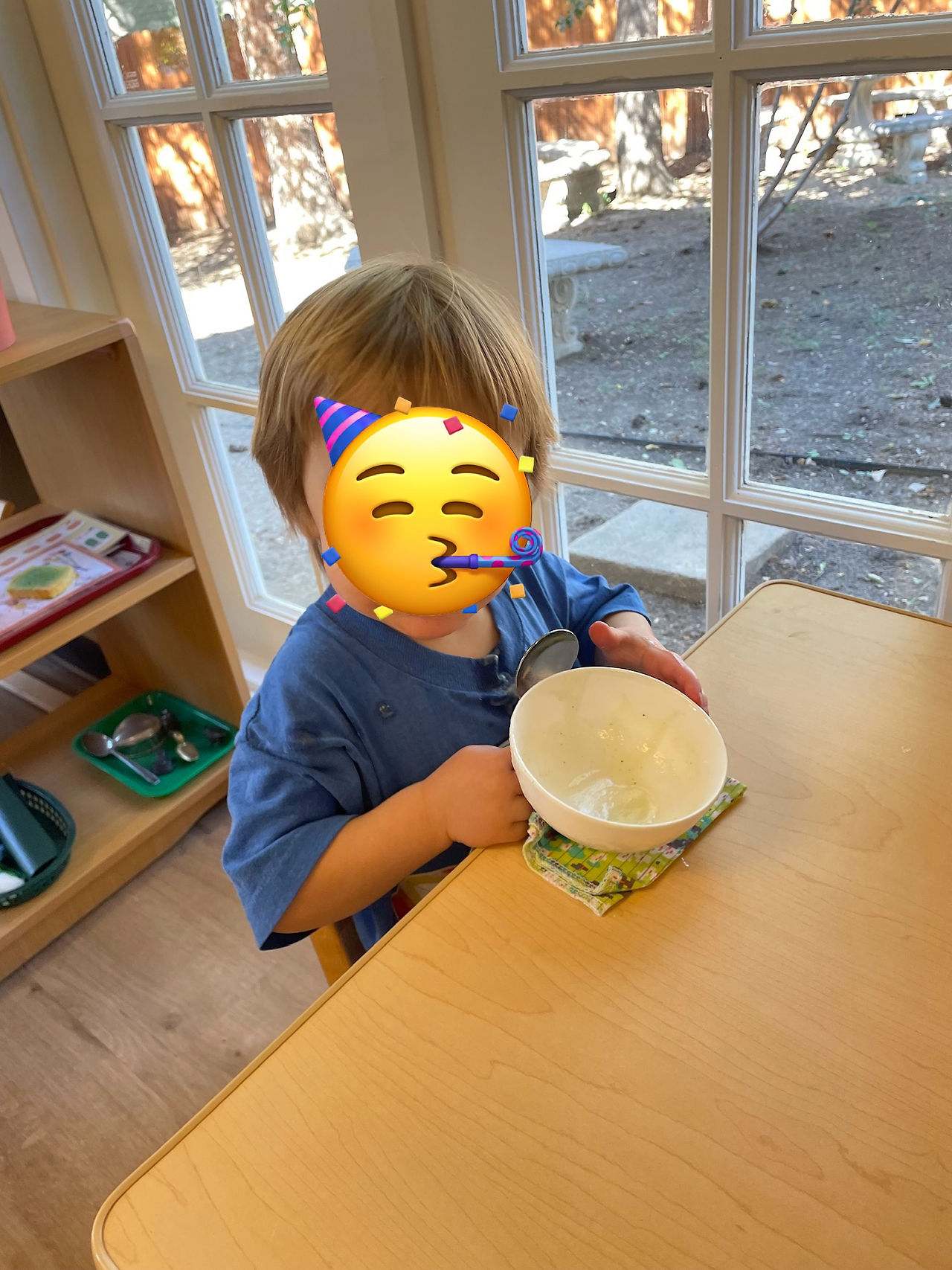 A 3 year old boy (face hidden by a sticker) showing an empty soup bowl