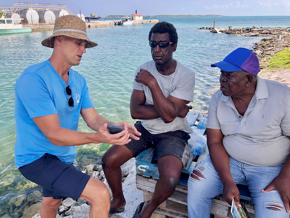 Fishers James Lockhart and Willis Jennings learn about the FisherFolkFirst app at South Caicos fishing dock.
