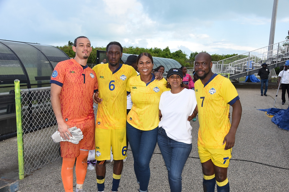 Governor Her Excellency Dileeni Daniel Selvaratnam (second left) and local football boss, Sonia Fulford, share a post-match photo moment with members of the TCI team, captain Billy Forbes (right), Sebastian Turbyfield (left) and Christopher Louisy (second left).