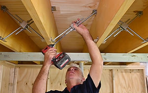 Image of Step 5 - showing how to place the Adjustable FloorLock Braces (AFB) in the mounting brackets, using a power driver.