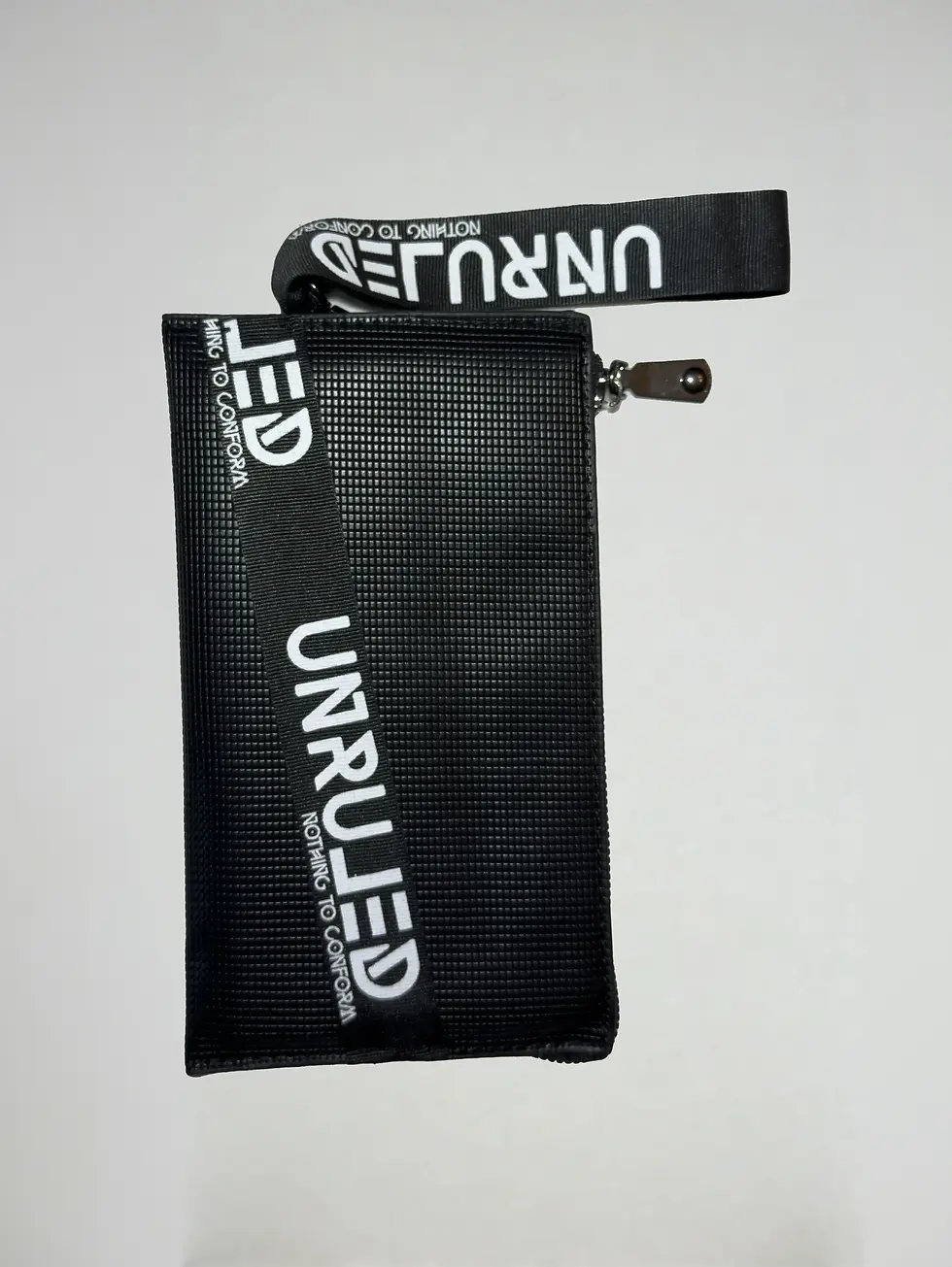 Front view of the UNRULED unisex pouch featuring a minimalist contemporary design.