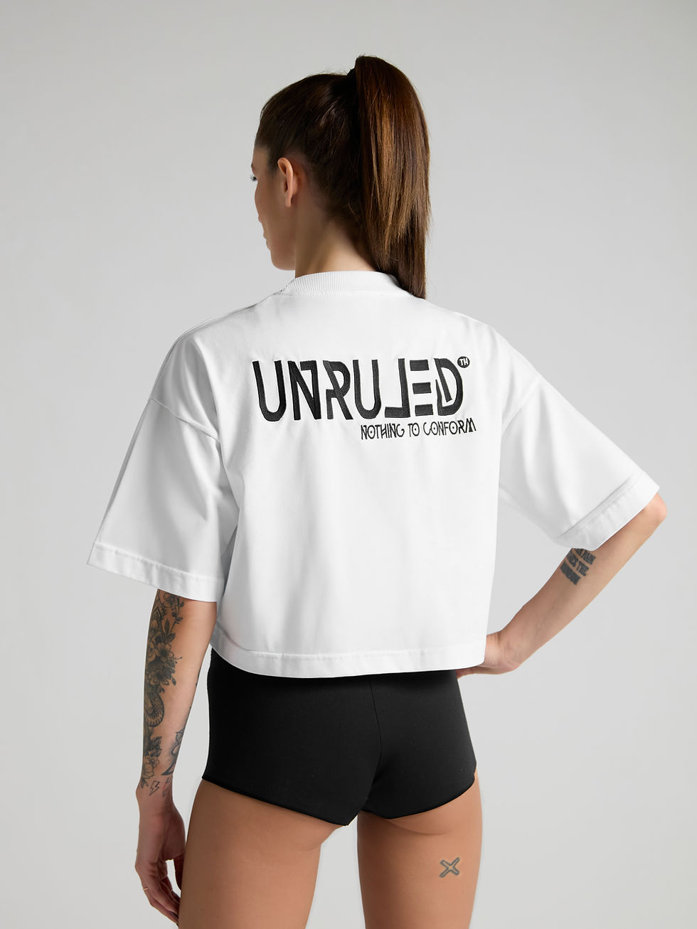 UNRULED women's white cropped top with minimalist contemporary design.
