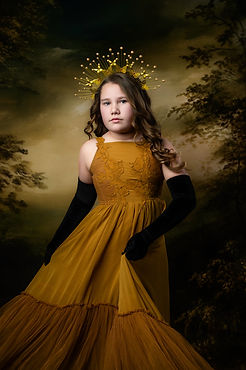 Strong, regal portrait of a 12 year old girl in a gold tone Joyfolie dress.