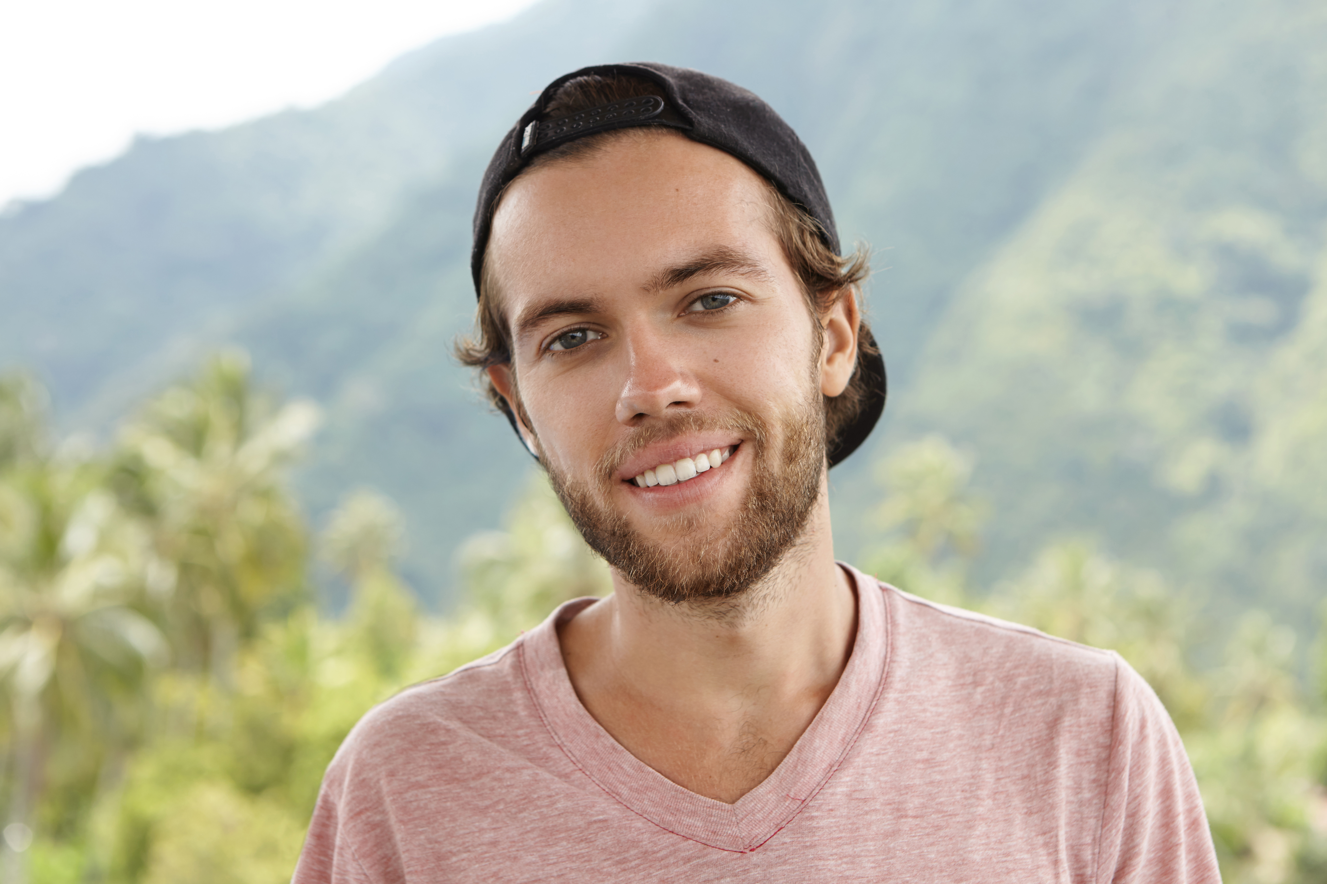 outdoor-shot-young-caucasian-man-with-beard-relaxing-open-air-surrounded-by-beautiful-moun