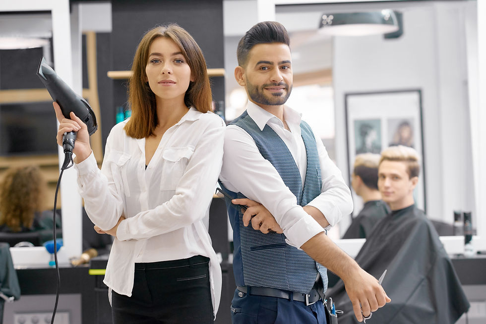 Friseur und Friseurin lächeln im Salon, Haartrockner und Schere