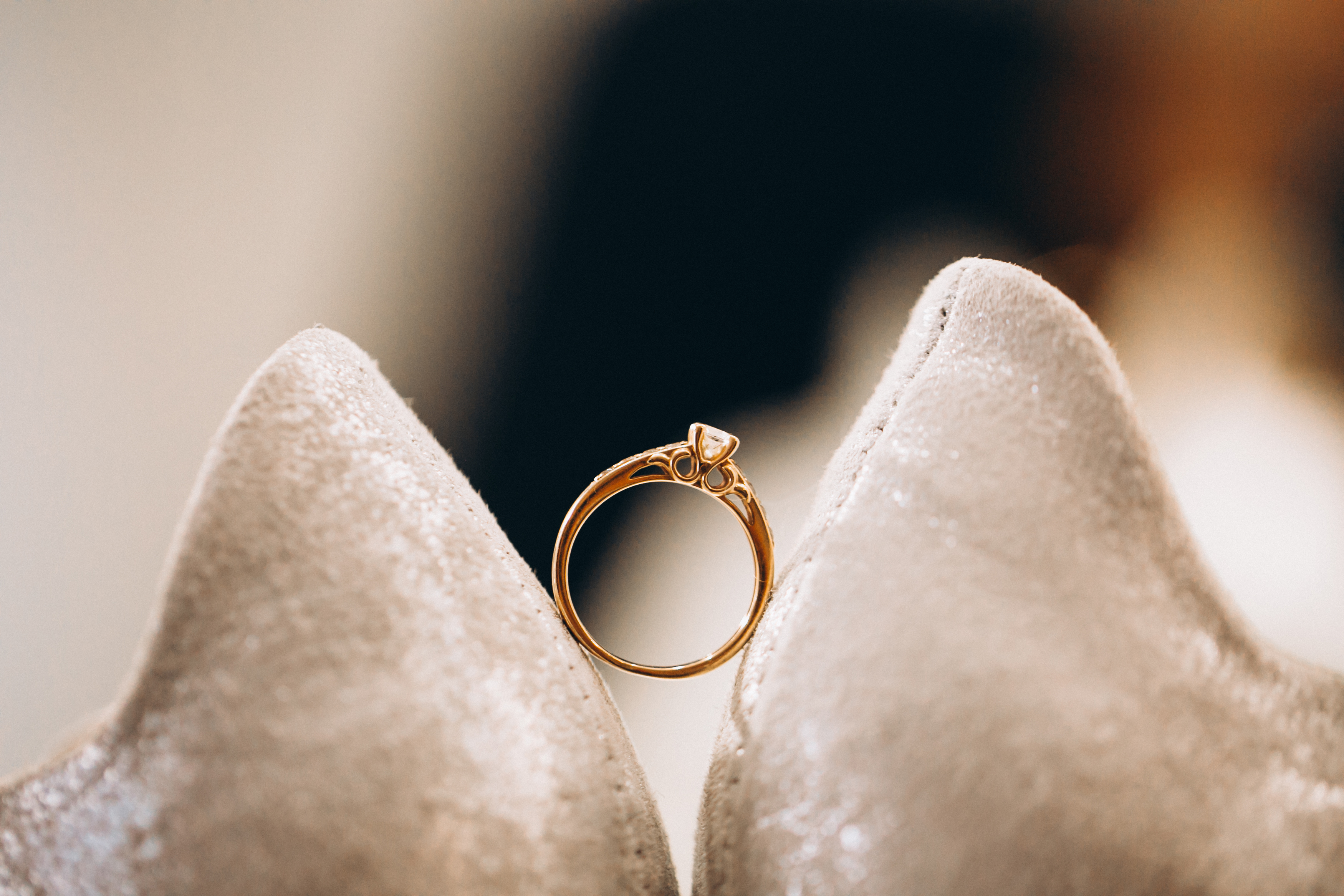 Elegant gold diamond ring on beige shoes