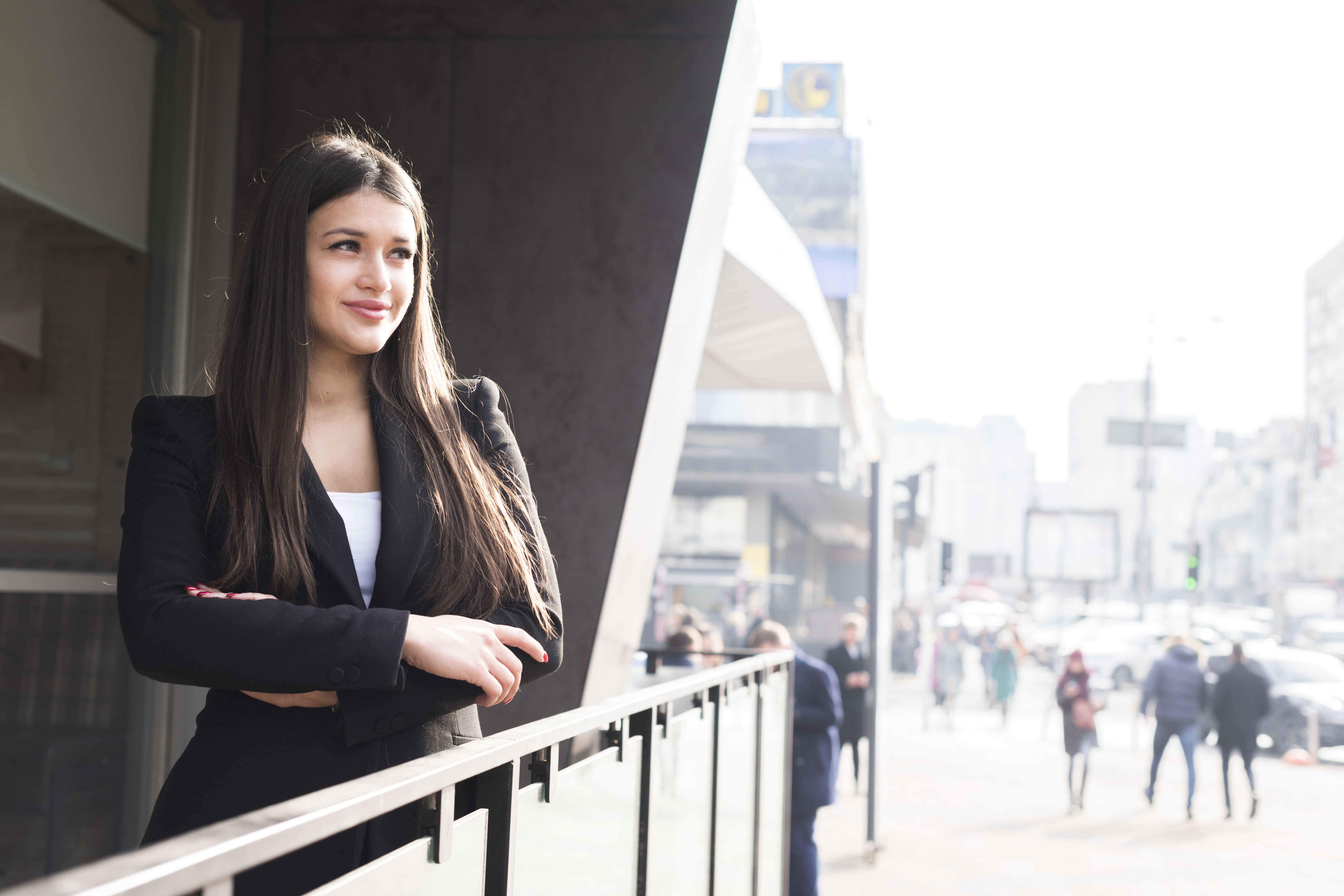 Frau im schwarzen Blazer, Stadt im Hintergrund