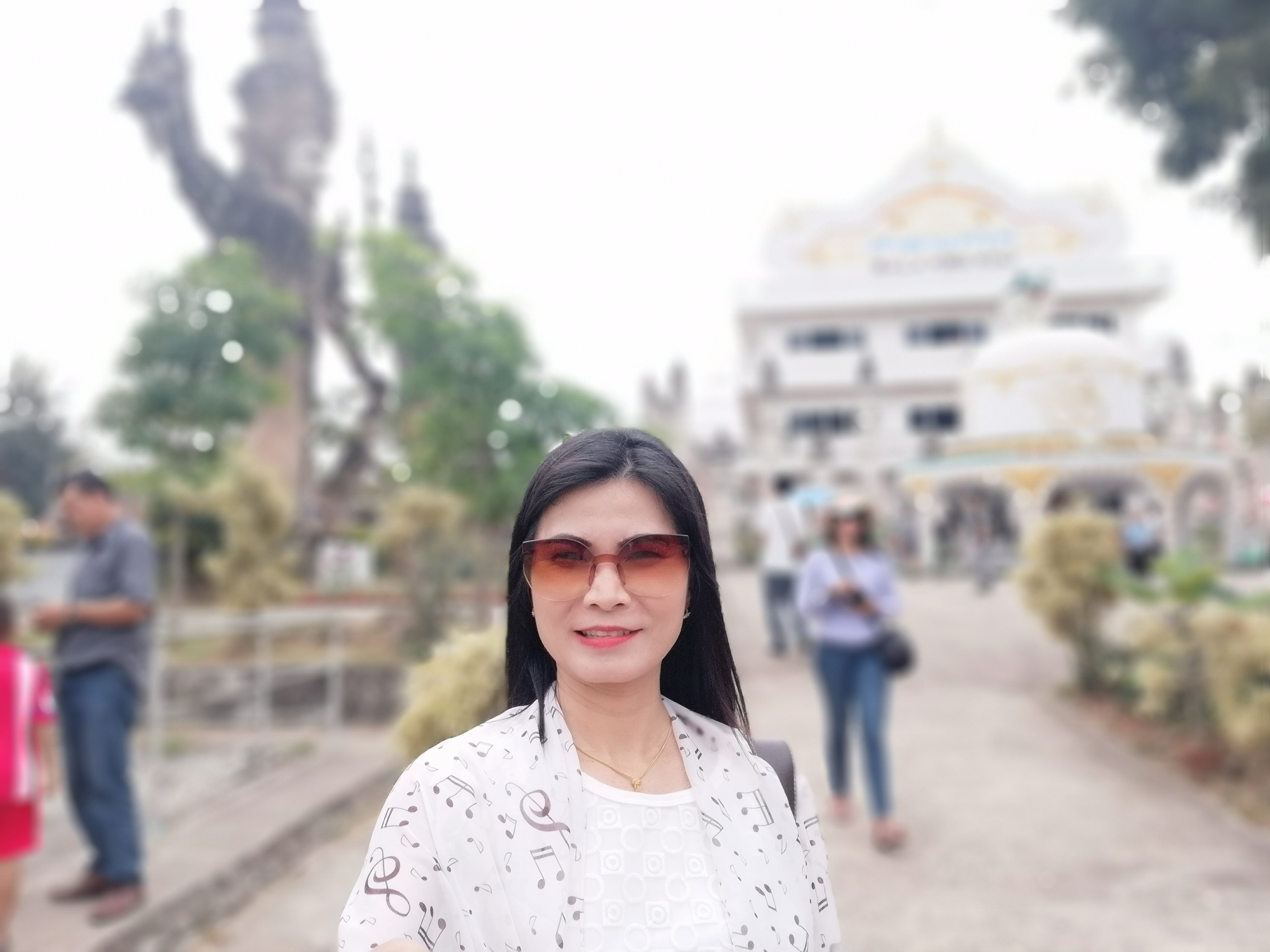 Frau mit Sonnenbrille vor Tempel