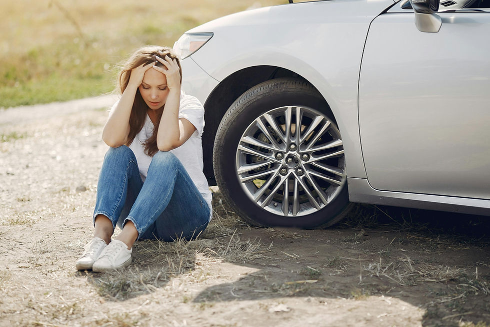 Woman sitting on ground, holding head in distress next to a silver car with an open hood. Our Attorneys of Westridge Law Group is prepared to help those in need of legal supports, covering the areas of Pasadena, LA.