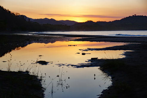 Sonnenaufgang am Strand Playa Carillo mit Spiegelung der Hügel im Wasser, Costa Rica