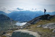 Wanderer mit Rucksack beim Abstieg vom Sidelhorn mit Blick auf Totensee und Grimselpass, im Hintergrund Alpenpanorama