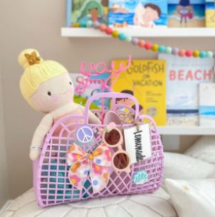 Thumbnail: Bubblegum Small Jelly Bag shown as a beach bag for a little girl with sunglasses, a hairbow, doll, and more