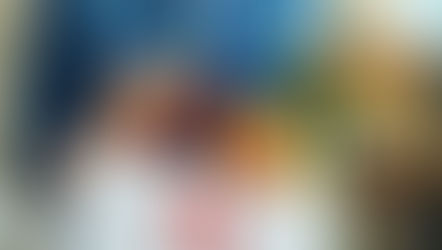 realtor holding a gift bag and a wrapped bottle of champagne