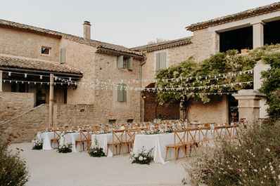 Vue du Domaine de Valbonne avec disposition des tables dans la cour, ambiance chic pour un repas de mariage en plein air