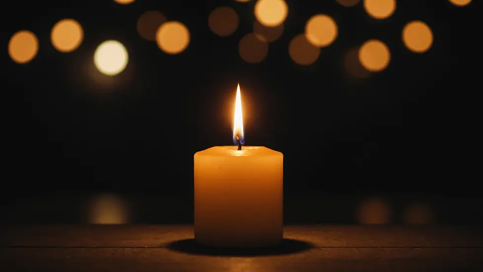 Eye-level view of an illuminated candle in a dark space