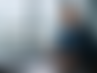 Yacht broker signing documents in a modern office overlooking a luxury yacht