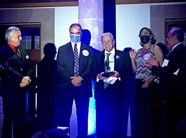 Award recipient with guests at night ceremony