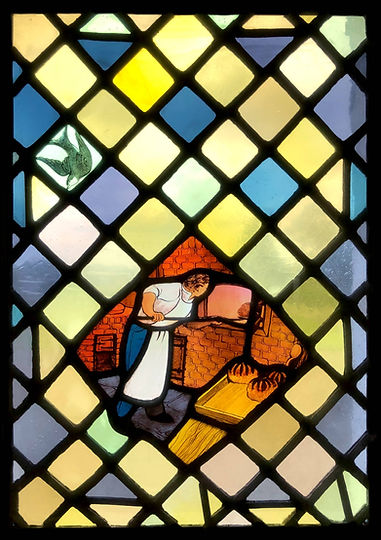 A traditional baker and a single swallow in the transom. Detail from Window 14: The Eucharistic Bread in the church of Saints Leonard and Fergus, Dundee, Scotland. Designed and made by AJ Naylor.