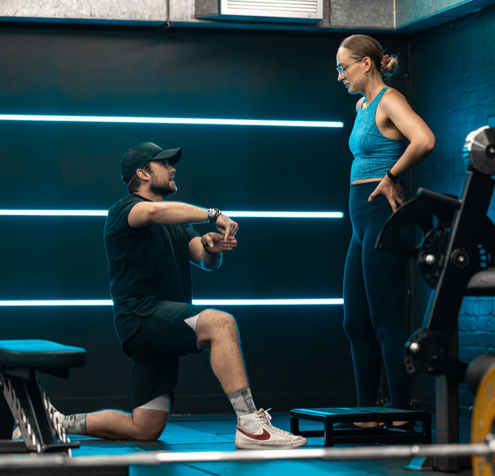 A trainer explaining a new exercise to one of his clients