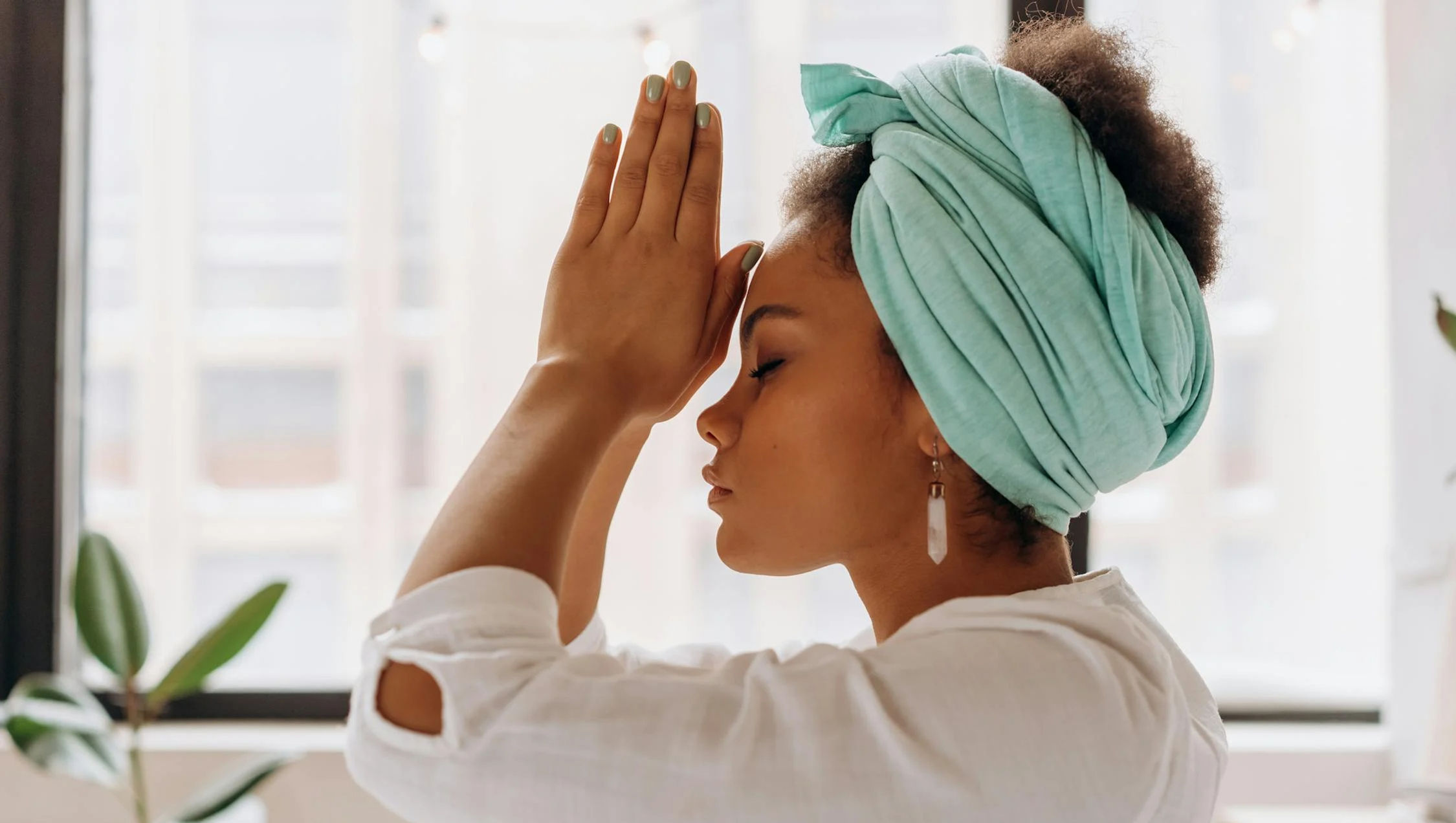 black-woman-holding-prayer-hands-in-front-of-her-face