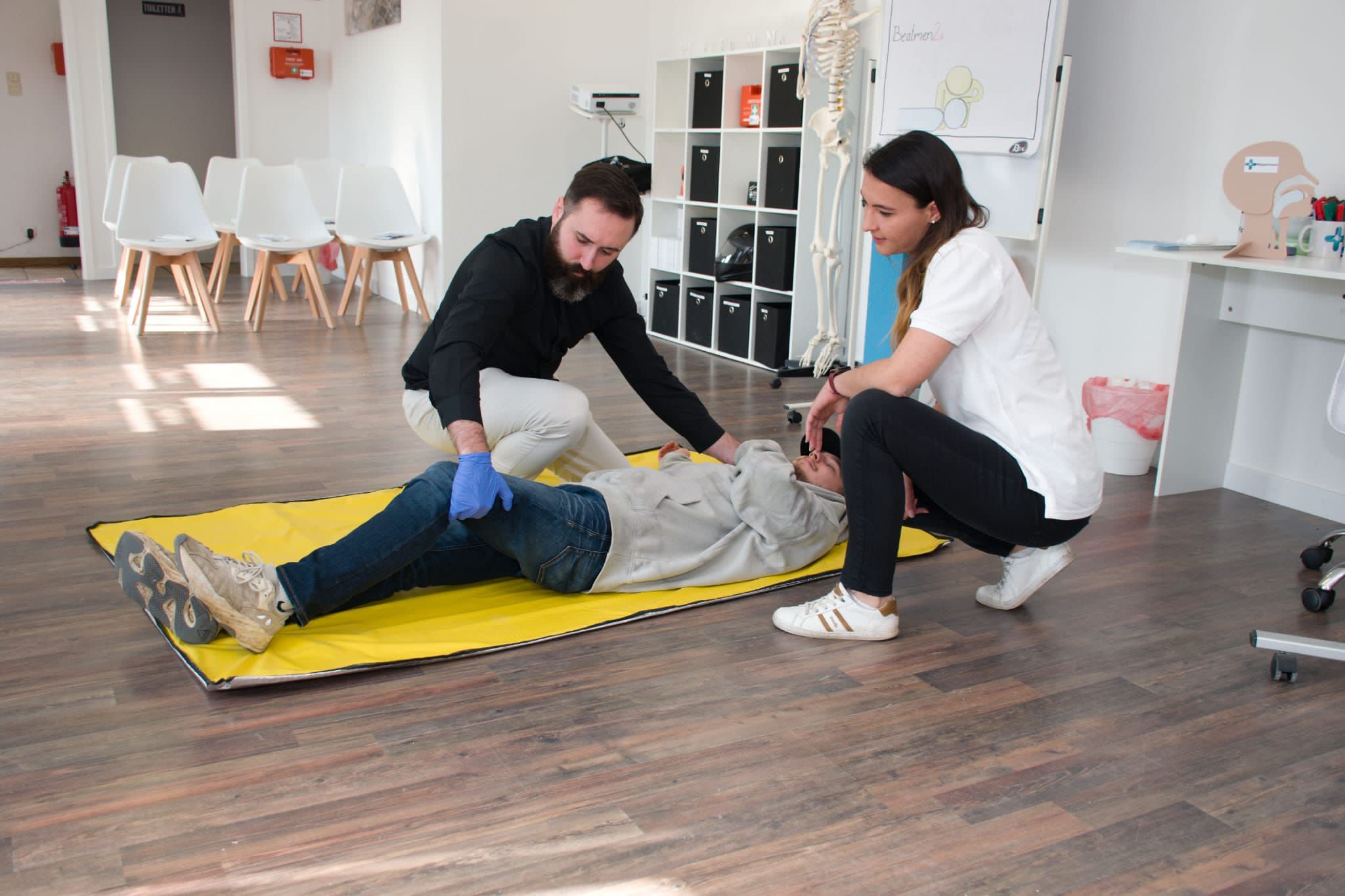 Teilnehmende üben die stabile Seitenlage im Erste-Hilfe-Kurs