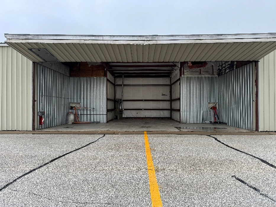 Exterior view of a t-hangar with the bi-fold door open.