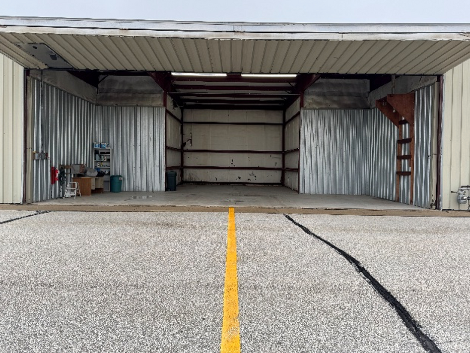 Exterior view of a t-hangar with the bi-fold door open.