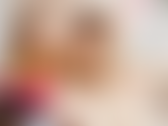 Mother and daughter sitting on a sofa reading together, child holding a pink heart for Valentine’s Day, cosy family learning moment at home.