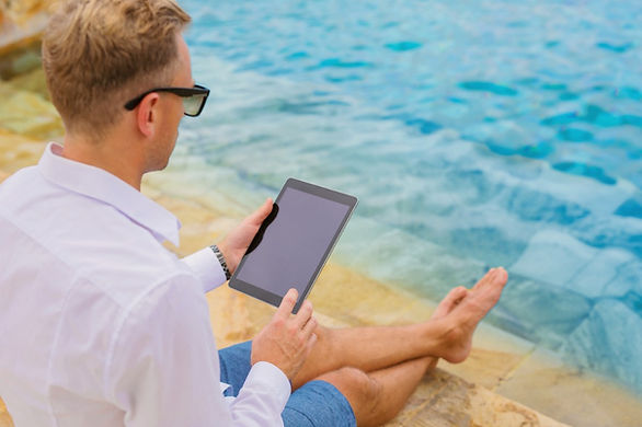 man-glasses-tablet-computer-by-the-pool-