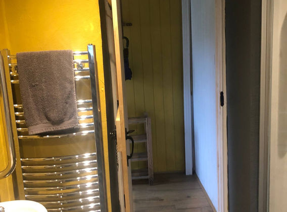 Open door into hall with large heated towel rail