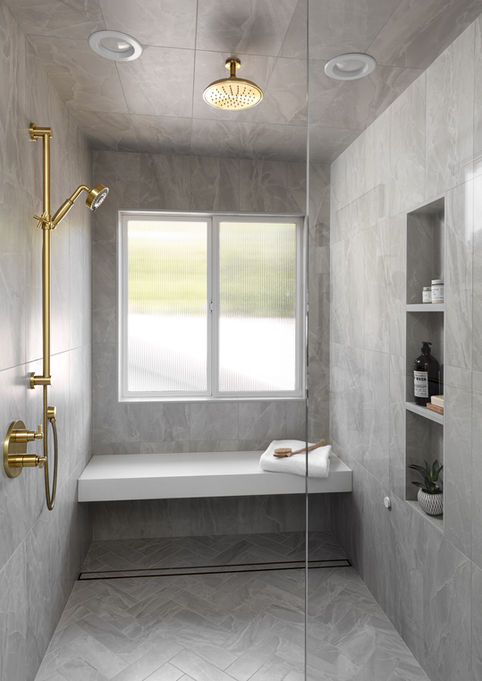 Luxury walk-in shower with gray marble tile, chevron floor pattern, built-in bench, and gold rainfall showerhead.
