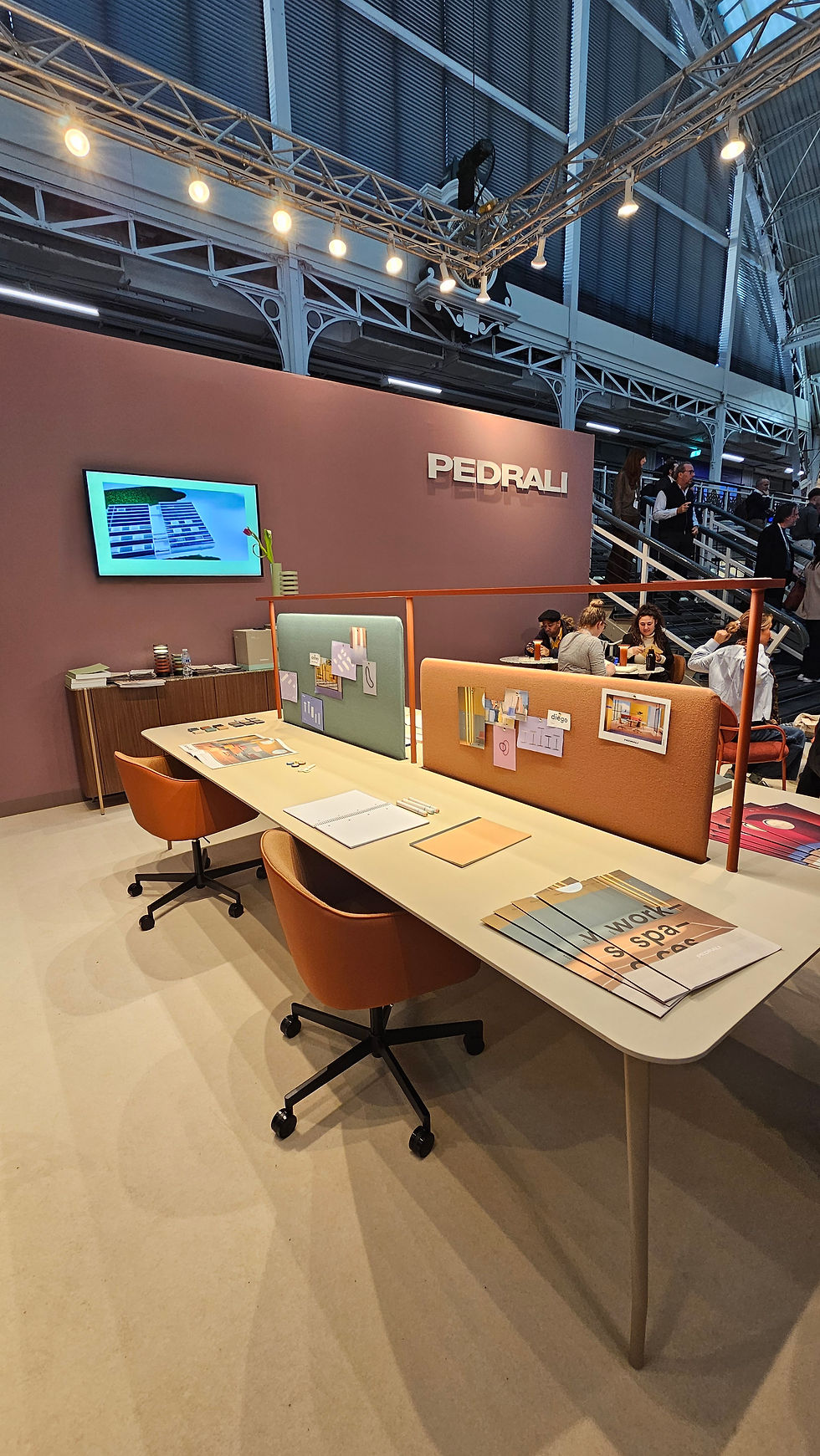 Modern booth at industry event with table, chairs, and screen