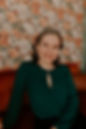 Headshot of Faune Benson Realtor, green shirt, in front of floral wallpaper.