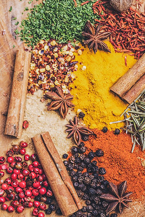 background image of herbs and spices on a wooden board