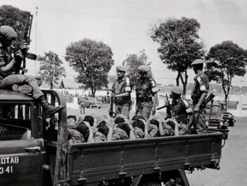 Tentara bersenjata mengangkut para terduga anggota Pemuda Rakyat, 10 Oktober 1965. (Bettmann/Getty Images).