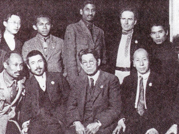 Tan Malaka (berdiri ketiga dari kiri) dan Ho Chi Minh (duduk pertama dari kiri) bersama delegasi dari berbagai negara menghadiri Kongres Komintern di Moskow, November-Desember 1922. (delpher.nl).