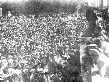 Henk Sneevliet (memegang tiang) berpidato di depan ribuan massa di Lapangan Merah, Moskow, 1920. Di belakangnya, Leon Trotsky sebagai penerjemah. (Repro Sneevliet Rebel karya Sal Santen).