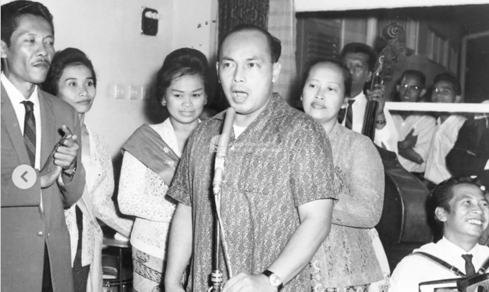 Menteri Penerangan Achmadi bernyanyi dengan iringan musik orkes dalam acara ramah tamah di rumahnya, 5 Februari 1966. (ANRI).