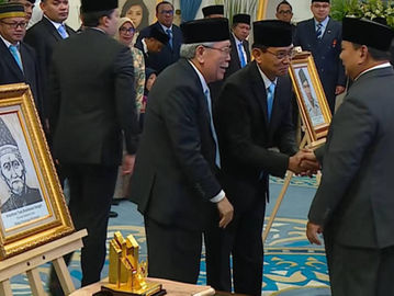 Lukisan Tuan Rondahaim Saragih Garingging (kiri dalam pigura). Tampak Presiden Prabowo Subianto menyalami perwakilan keluarga Tuan Rondahaim dalam acara penganugerahan gelar Pahlawan Nasional di Istana Negara, 10 November 2025. (BPMI Setpres/Laily Rachev).