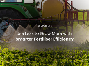 A green tractor sprays CropBioLife on crops in a field with a yellow tank and red spray arms. Mist creates a hazy effect, evoking an agricultural scene.
