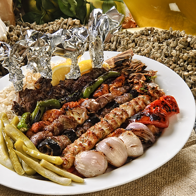 Gemischte Grillplatte mit Schawarma, Kafta und Lammspießen auf einem Holzbrett